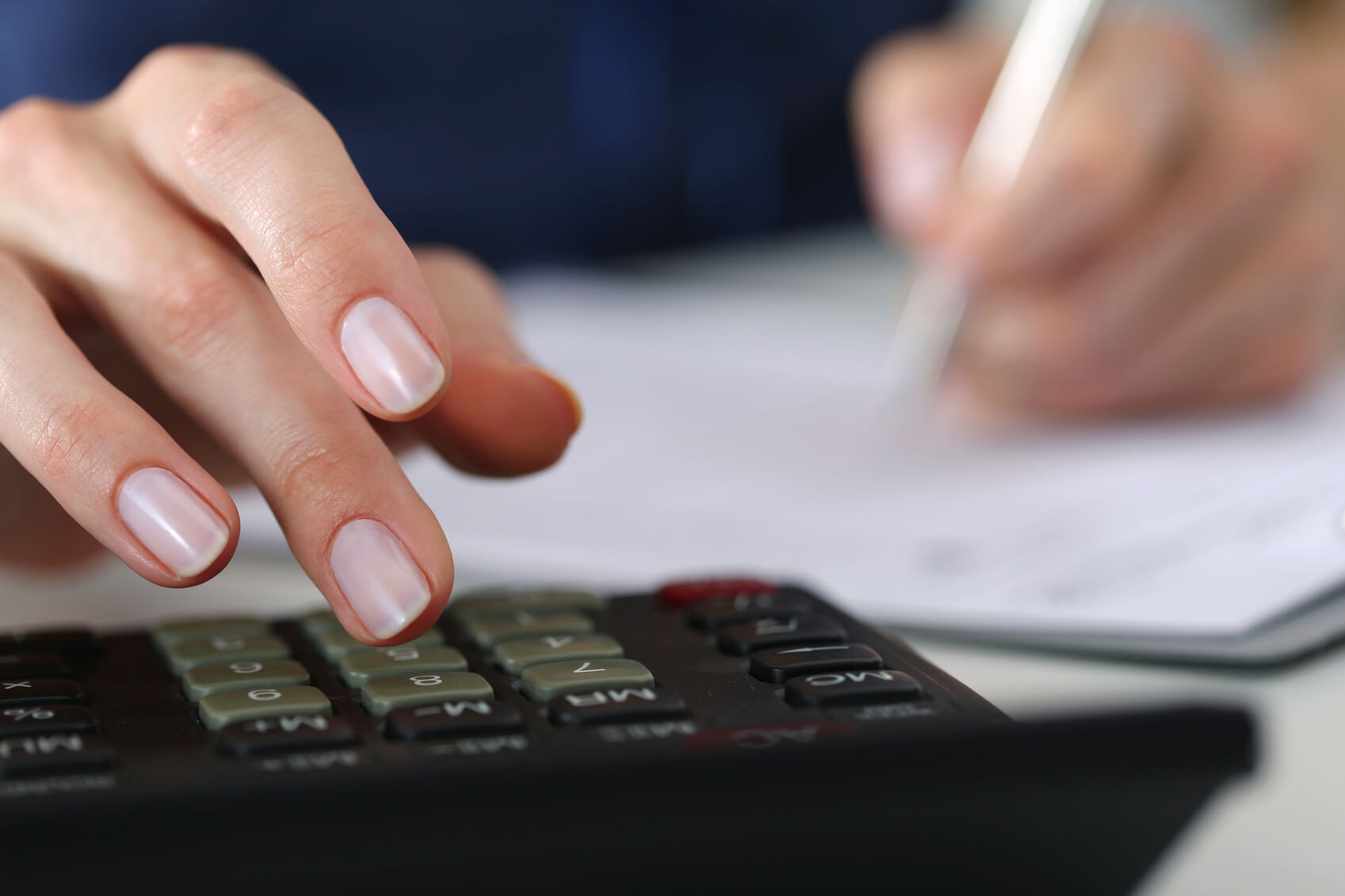 Close up of female accountant or banker making calculations. Savings, finances and economy concept